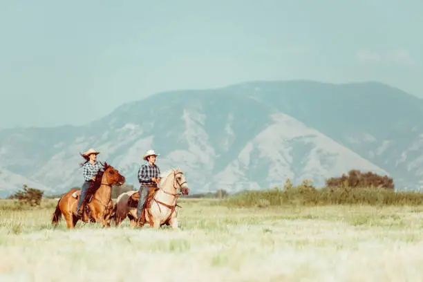 Photo of Cowboy couple horseback riding