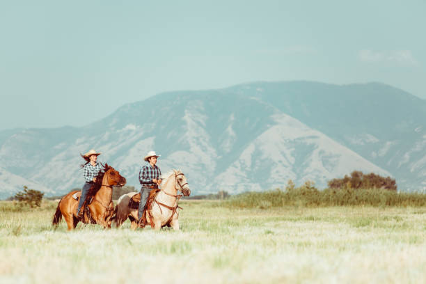ковбой пара верховая езда - horseback riding cowboy riding recreational pursuit стоковые фото и изображения