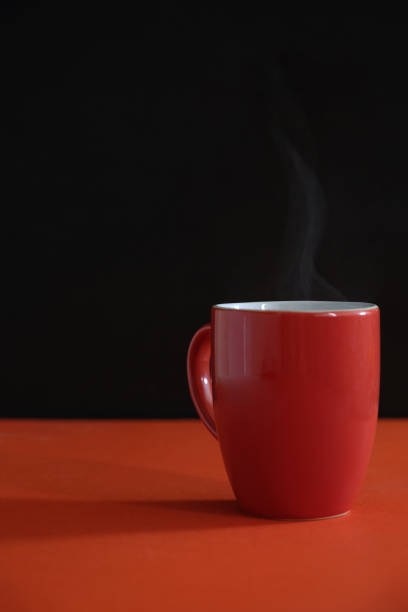 istock an orange mug with steamy hot coffee 952682458