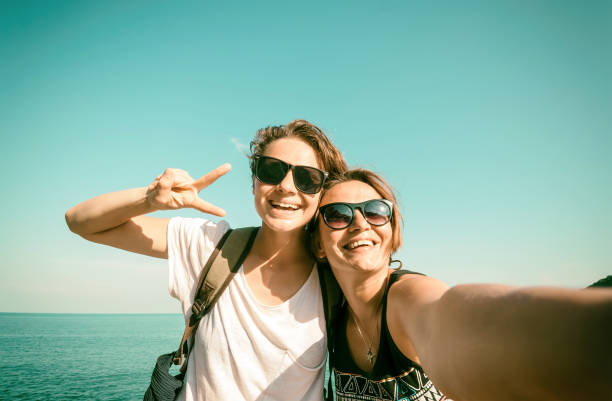 Two beautiful young women making selfie on the beach