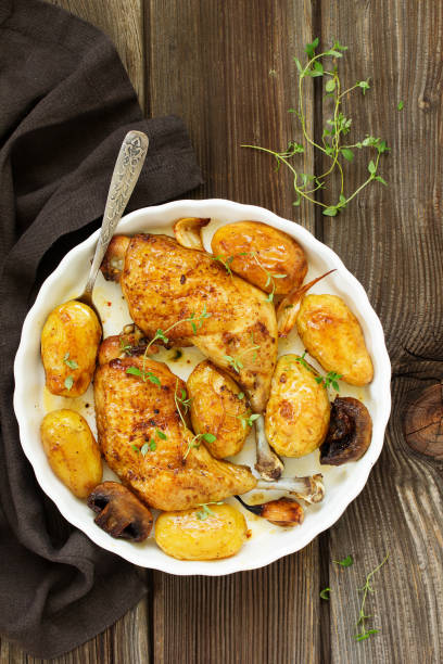 istock Baked chicken thigh with potatoes and vegetables. 952708434