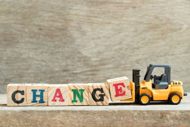 istock Toy yellow forklift hold block letter e to complete word change on wood background 952708558