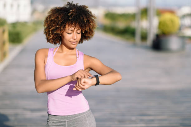 istock Young black woman using smartwatch touching touchscreen 952709116