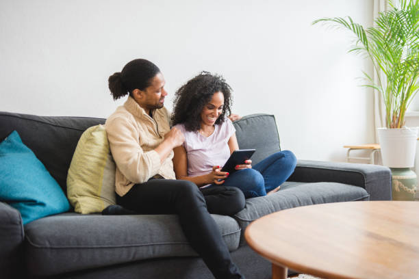 istock African American couple using digital tablet on the sofa 952711942