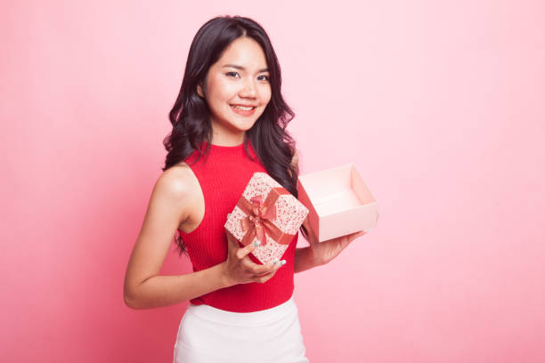 istock Young Asian woman open a golden gift box. 952716224