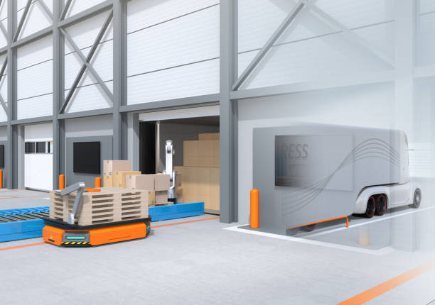 istock Industrial robot unloading parcels from semi truck, Automatic Guided Vehicle carrying set of pallets to the robot position 952716244