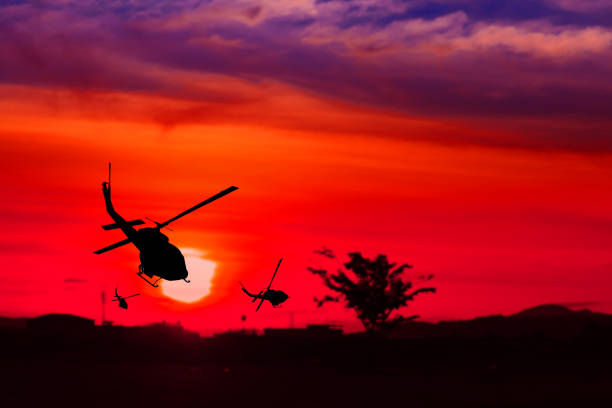 istock soldier silhouette in rappelling climb down from helicopter on sunset with copy space add text ( Concept stop hostilities To peace) 952716260