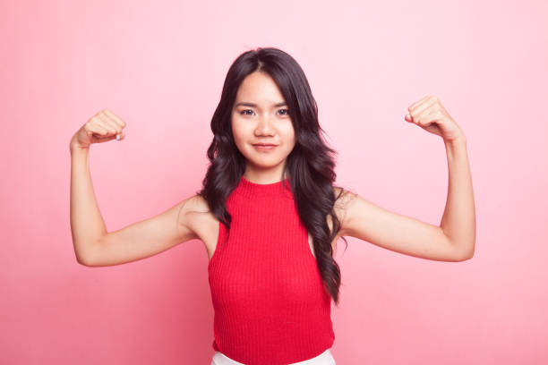 istock Beautiful young Asian woman flex bicep. 952719864