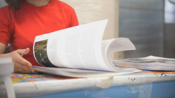 istock Hands of female worker in typography turning printed pages 952723690