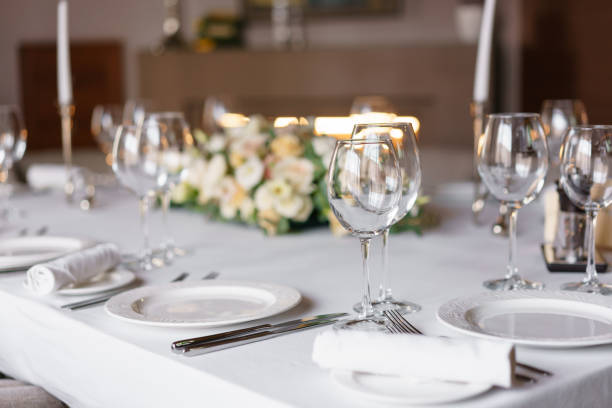 istock Table setting in the restaurant, glasses in the foreground. Luxury wedding reception. Flower arrangement on table in restaurant. Stylish decor and adorning. 952724504