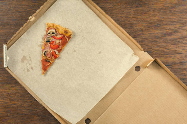 one last piece of pizza in the open delivery box. Foood concept