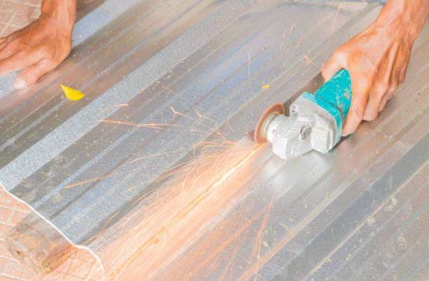 istock electric wheel grinding on cutting metal sheet roof  in constructor works. select focus with shallow depth of field 952730472