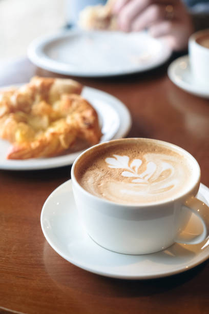 istock Man enjoying his Danish pastry with a cup of flat white coffee 952739920