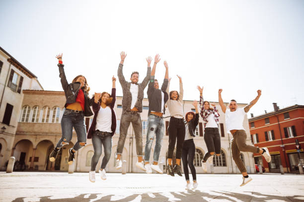 group of friends jumping all together on the city group of friends jumping all together on the city jumping teenager fun group of people stock pictures, royalty-free photos & images