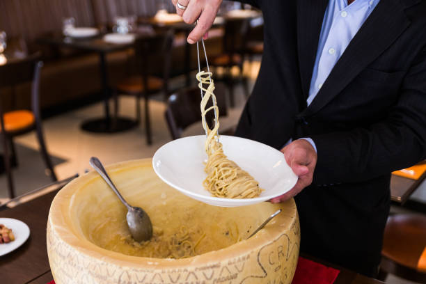 istock Chef neatly plating spaghetti carbonara in cheese wheel on white plate. 952742352