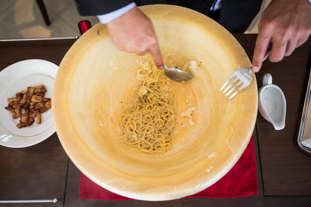 istock Chef making spaghetti carbonara in cheese wheel with tourched brandy and fried bacon. 952742438