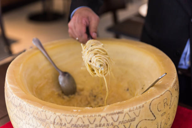 istock Chef making spaghetti carbonara in cheese wheel with tourched brandy and fried bacon. 952742528