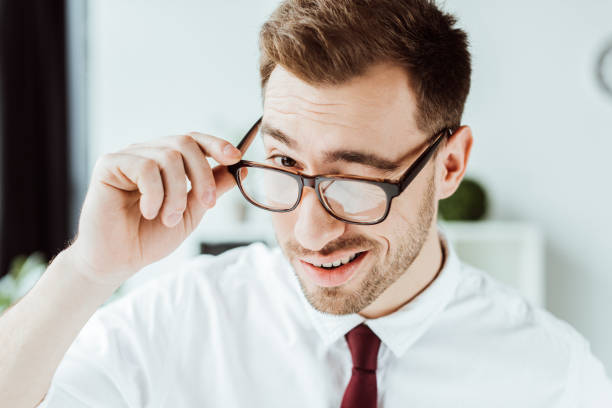 istock handsome smiling businessman winking in glasses 952744036