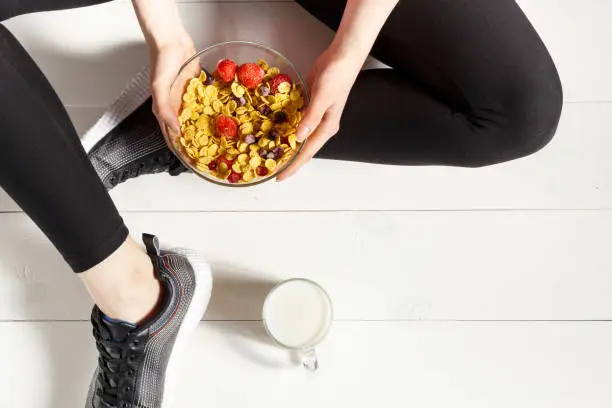 Sports girl and healthy food on a floor. Concept of healthy food. Top view. Copy space