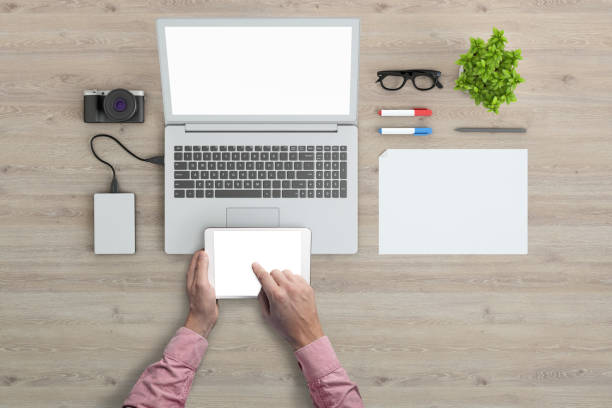 istock Man holding tablet knolling overhead view 952755188