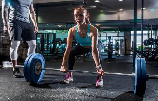 istock Young Woman Lifting Heavy Weights 952755728