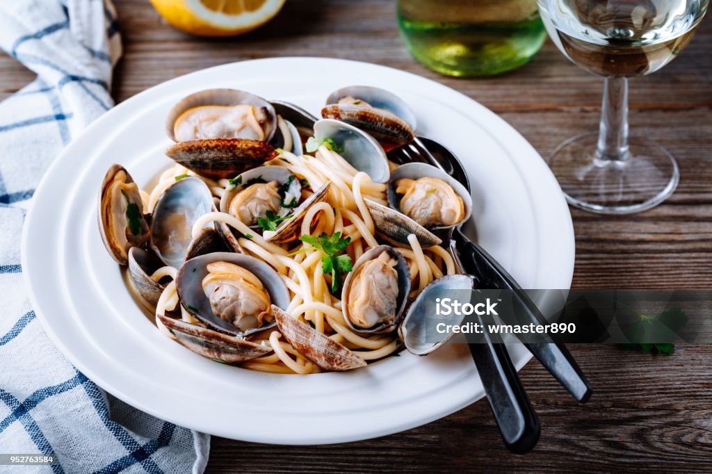 Traditional italian seafood pasta with clams Spaghetti alle Vongole Traditional italian seafood pasta with clams Spaghetti alle Vongole on wooden background Seafood Stock Photo