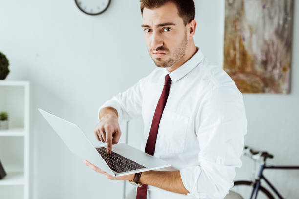 istock angry businessman in tie using laptop in office 952766314
