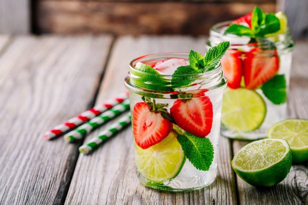 acqua detox con fragola, lime e menta. cocktail estivo ghiacciato o limonata in barattolo di muratore di vetro - juice glass healthy eating healthy lifestyle foto e immagini stock