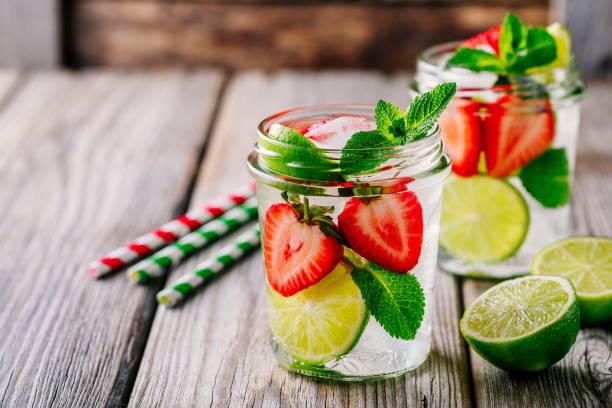 Detox water with  strawberry, lime and mint. Ice cold summer cocktail or lemonade in glass mason jar Infused detox water with  strawberry, lime and mint. Ice cold summer cocktail or lemonade in glass mason jar infused water stock pictures, royalty-free photos & images