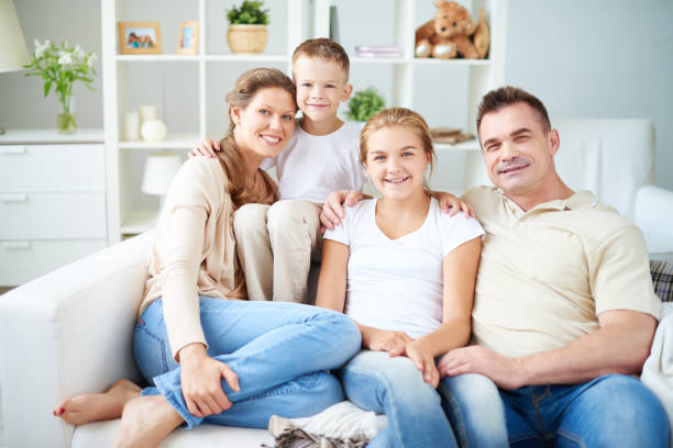 istock All family sitting on sofa and looking at camera 952769030