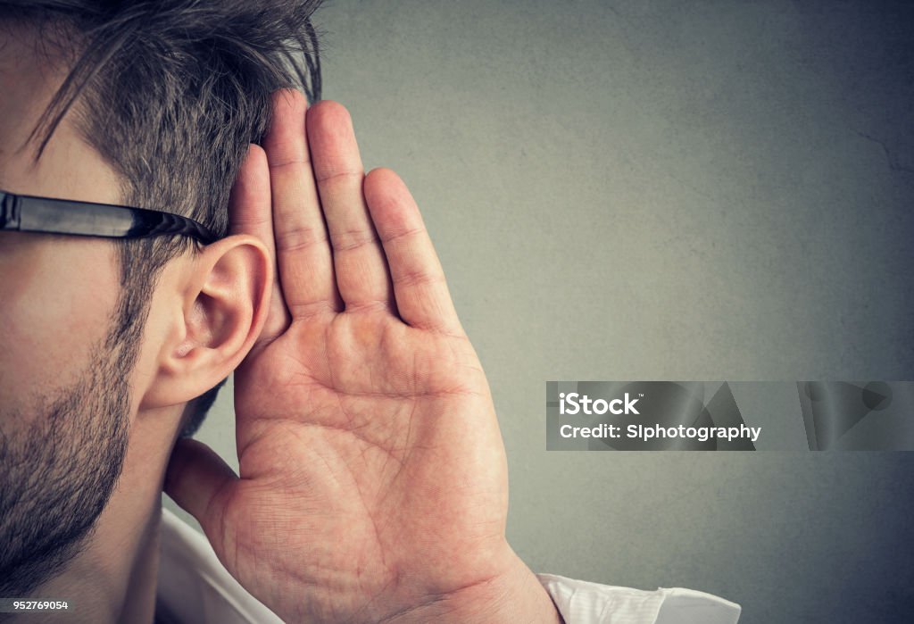 homem segura sua mão perto da orelha e escuta com atenção - Foto de stock de Escutar royalty-free