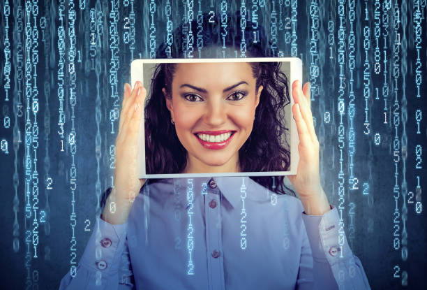 woman holding tablet with her face displayed on a screen Happy woman holding tablet with her face displayed on a screen isolated on binary code background synthetic identity theft stock pictures, royalty-free photos & images