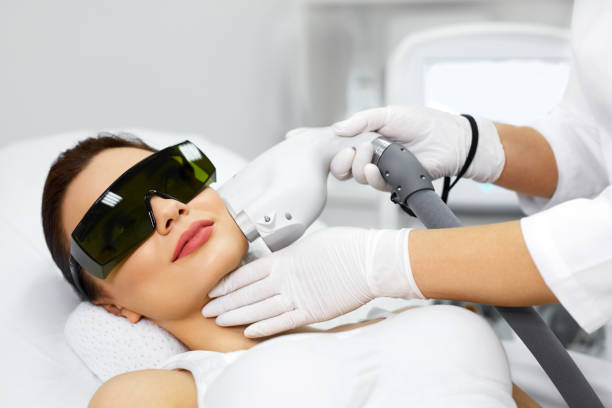 Woman Receiving Laser Hair Removal Procedure At Beauty Salon Cosmetology. Beautiful Woman Receiving Laser Hair Removal Procedure At Beauty Salon. Closeup Of Beautician Hands Doing Beauty Treatment For Female Face At Spa Salon. Facial Treatment. High Resolution hairless animal photos stock pictures, royalty-free photos & images