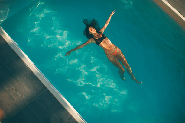 istock Young woman floating in the pool 952776700