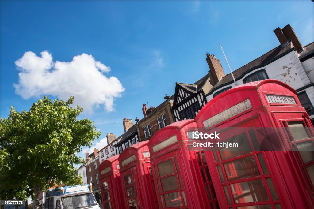 antique telephone boxes in town square a row of four telephone boxes in summer in Ripon in England Ripon - England Stock Photo