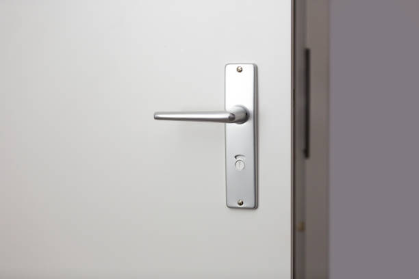 istock Metal door handle with key on white door 952777728