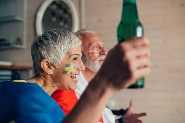 istock Mature couple watching soccer game and drinking beer 952779304