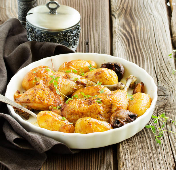 istock Baked chicken thigh with potatoes and vegetables. 952779630