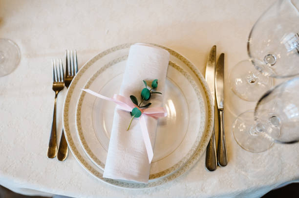 istock Serving, setting table. Two plates and silverware cutlery  linen napkin are decorated with pink ribbons and branch greens. Wedding table decoration. Artwork. flat lay. top view. 952786600