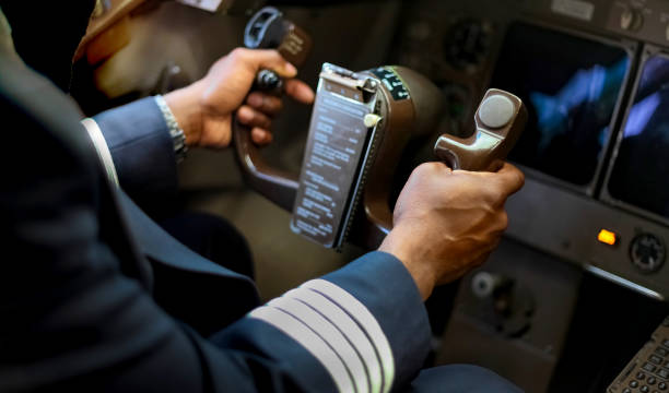 Cropped Hands of African Pilot flying a commercial airplane Cropped Hands of African Pilot flying a commercial airplane, cockpit view close up of hands throttle photos stock pictures, royalty-free photos & images