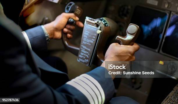 Cropped Hands Of African Pilot Flying A Commercial Airplane Stock Photo - Download Image Now