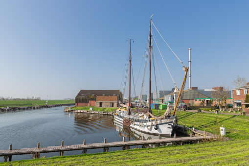 Outer harbor with wooden sailing vessel in old historic Dutch fishing village Workum