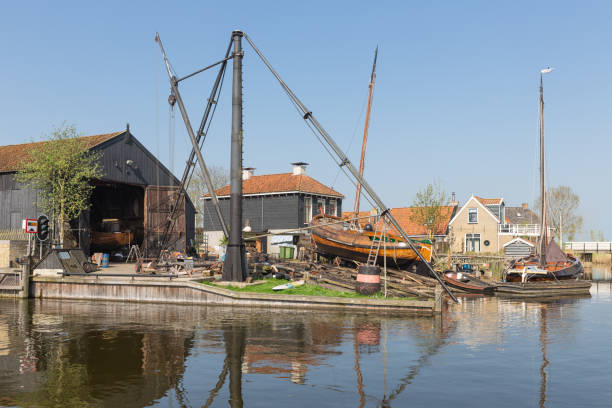 navires historiques au chantier naval avec cale de lancement dans le village néerlandais de workum - boathouse work tool equipment old photos et images de collection