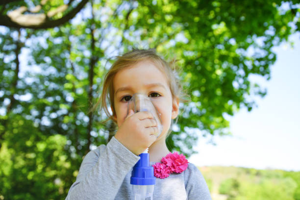 istock Girl using asthma inhaler in a park 952791552