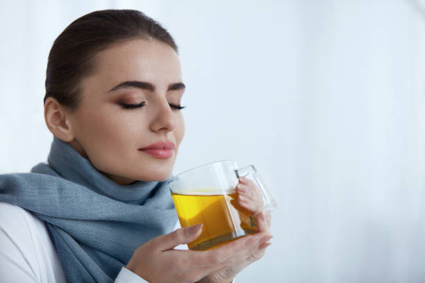 istock Beautiful Woman Drinking And Smelling Hot Warming Yellow Drink 952795992