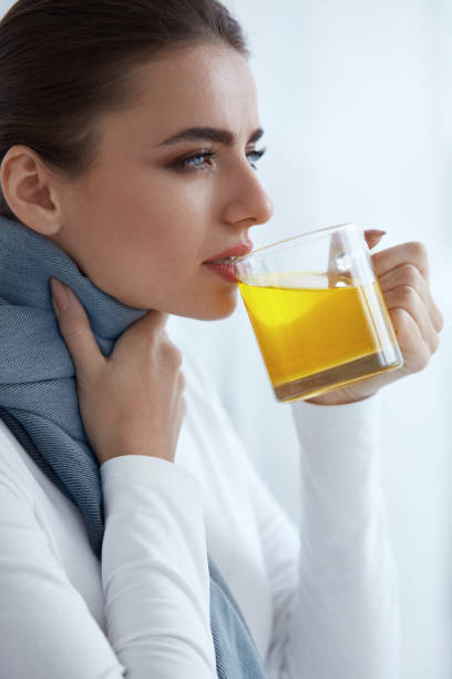 istock Beautiful Sick Woman Drinking Yellow Drink, Medicine From Cold 952796146