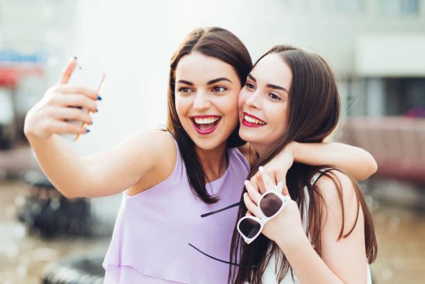 istock Two beautiful sisters do selfie on the street 952805114
