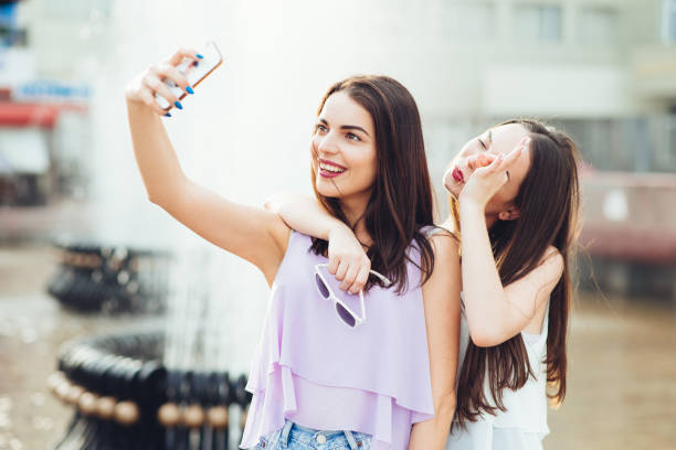 istock Two beautiful sisters do selfie on the street 952812288