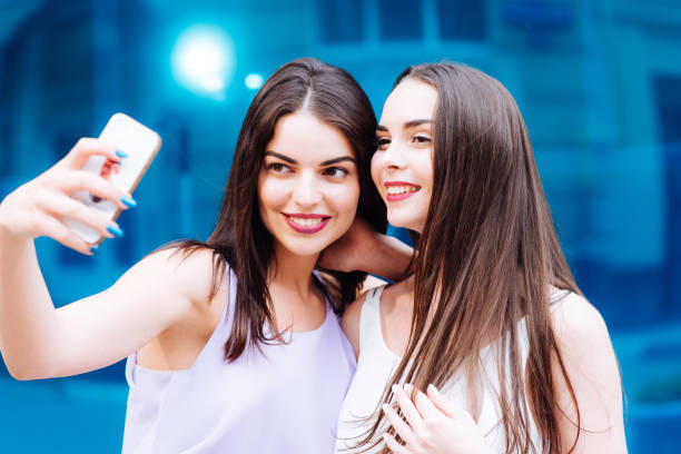 istock Two beautiful sisters do selfie on the street 952812664
