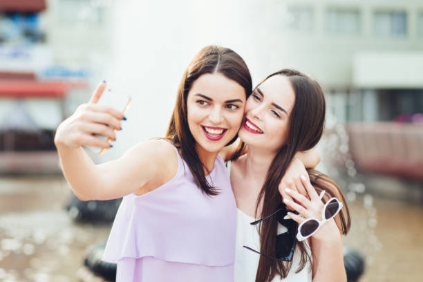 istock Two beautiful sisters do selfie on the street 952817978